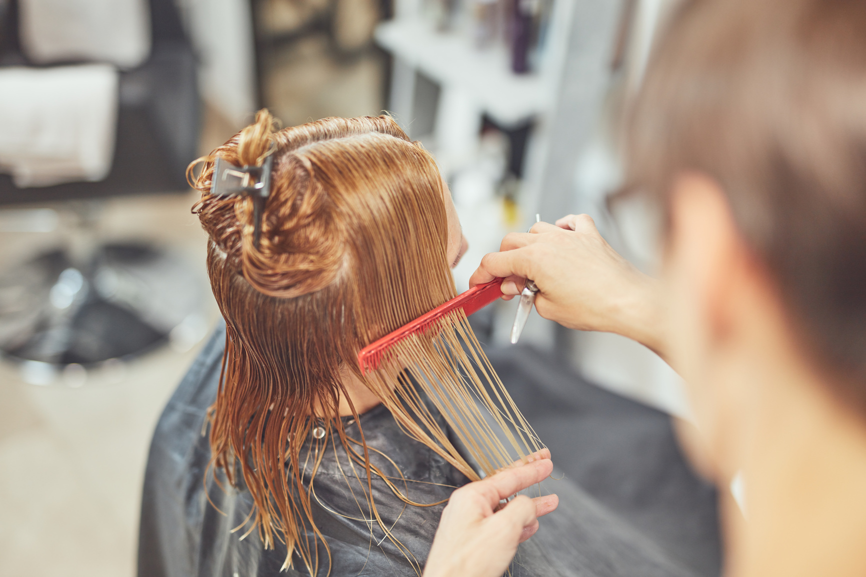 Hair dresser cutting hair in a salon.